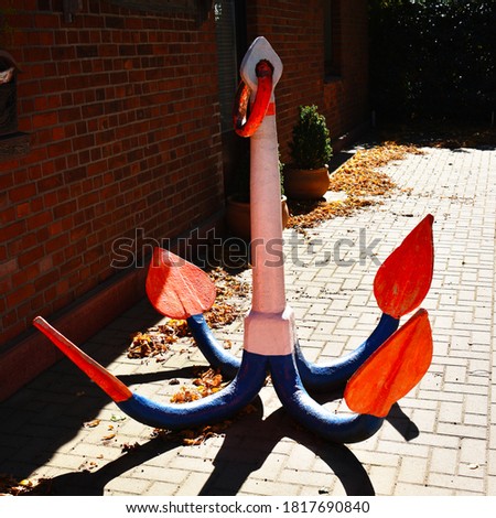 a large colourful anchor in front of a building with red brick near Nienburg