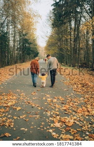 Beautiful and stylish family walking in the autumn forest