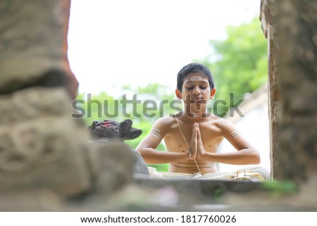the indian priest child doing meditation