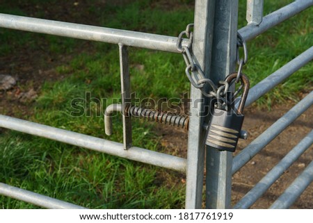 Silver farm gate and black padlock