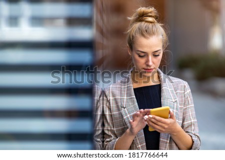 Young businesswoman using a mobile phone in the city
 Royalty-Free Stock Photo #1817766644
