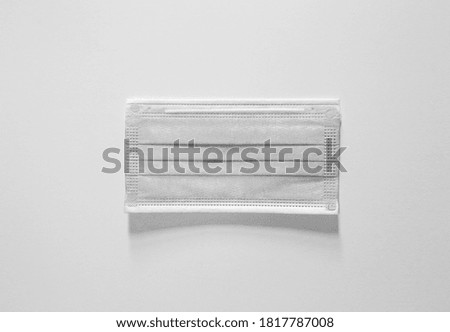 Disposable surgical face mask covering mouth and nose is gray in color. Royalty-Free Stock Photo #1817787008