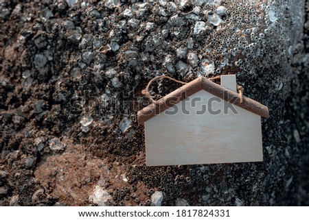 Wooden house as symbol on rock background