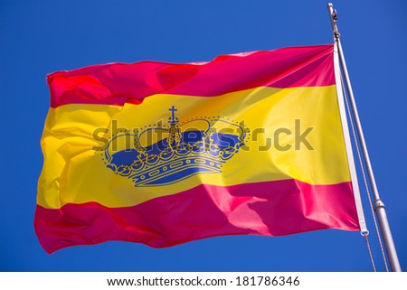Spain red and yellow flaw waving on wind under blue sky