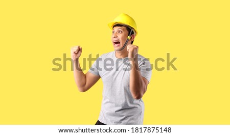 Asian man Industry worker or engineer working an architect builder Happy excited raising his fists on yellow background in studio With copy space.