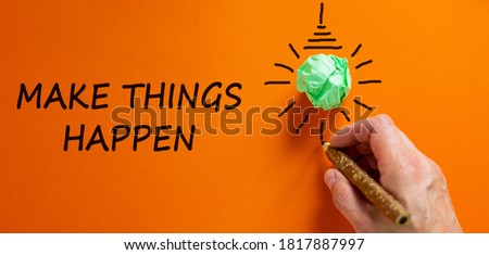 Male hand writing a 'Make things happen' sign next to a light bulb shape over orange background. Copy space. Business concept.