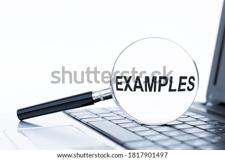 A concept image of a magnifying glass isolated white background with a word EXAMPLE zoom inside the glass on laptop keyboard