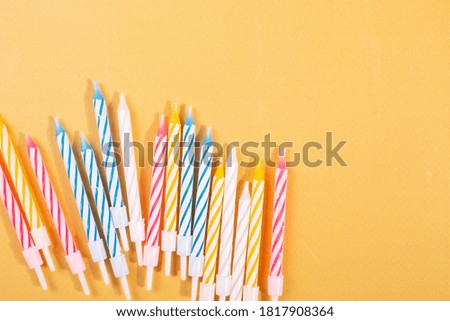 a group of festive birthday candles on yellow surface