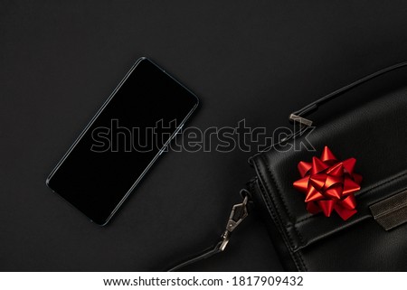 Creative flat lay  top view composition with bag, smartphone and bow. Black friday thanksgiving christmas template fashion shopping sale mockup 