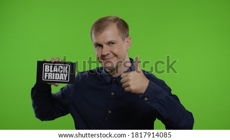 Happy cheerful blonde man holding Black Friday inscription and showing thumb up. Guy rejoicing with good holiday sale discounts. Shopping with low prices, big sale concept. Chroma key. 6k downscale