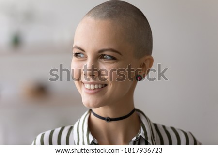 Close up of smiling hairless millennial punk girl look in window distance dreaming thinking. Dreamy bald young creative Caucasian woman lost in thoughts pondering or planning. Art, vision concept. Royalty-Free Stock Photo #1817936723
