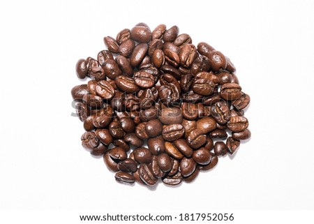 Arabica coffee beans arranged in circles on white background.
Photography taken in studio, with a close-up of the coffee capturing the brightness and color of the beans with total reality.