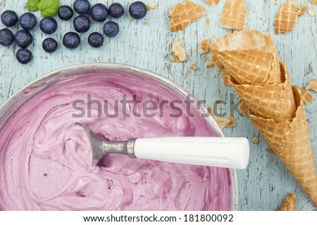 Homemade blueberry ice cream on vintage light blue wooden background