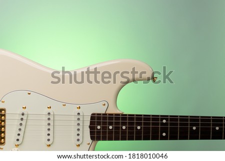 Close up white guitar on a green background