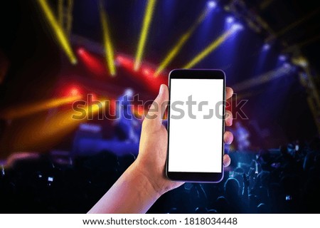 Hand with a smartphone records live music concert festival.