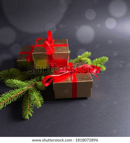 Christmas gifts with red ribbons arranged with Christmas tree branches