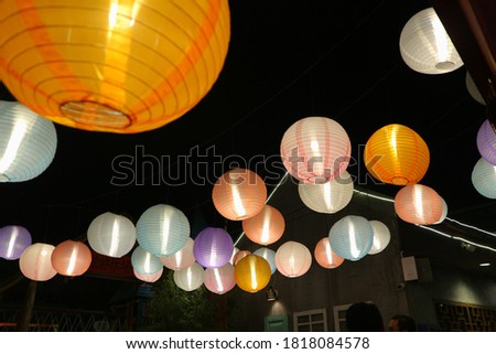 Several hanging lanterns at the amusement park at night. Dark mood. Selective object, selective focus. 