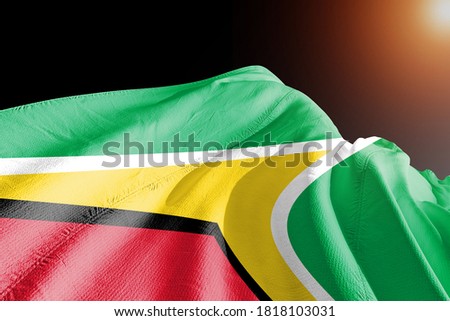Guyana national flag cloth fabric waving on beautiful sky.