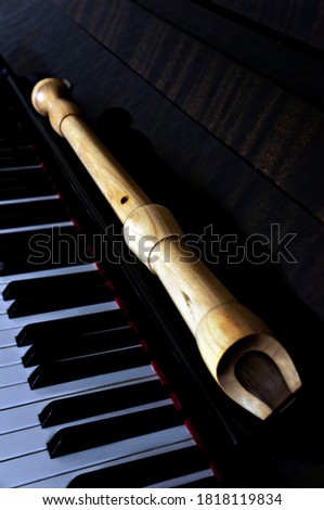 Wooden flute lying on the piano