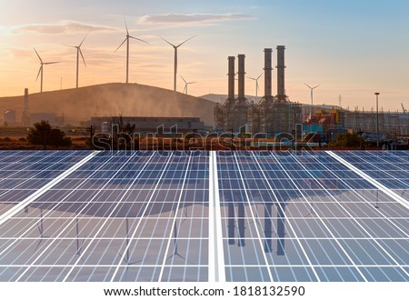 Natural gas processing plant with Renewable energy wind turbines generating electricity reflection to solar panels at sunset - Industrial concept  Royalty-Free Stock Photo #1818132590