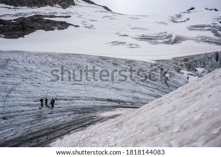 Extreme climbers lined up in one line crossing a glacier in Swiss Alps during a summer season