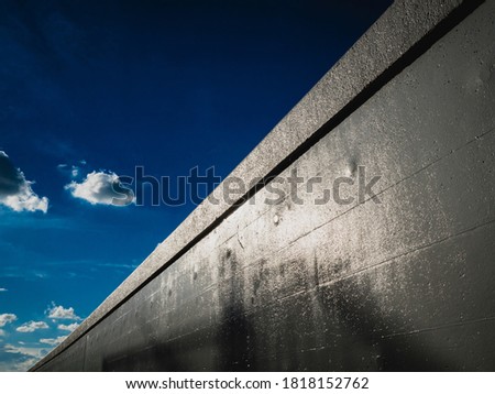 Blue skies and glistening retaining walls at dusk.