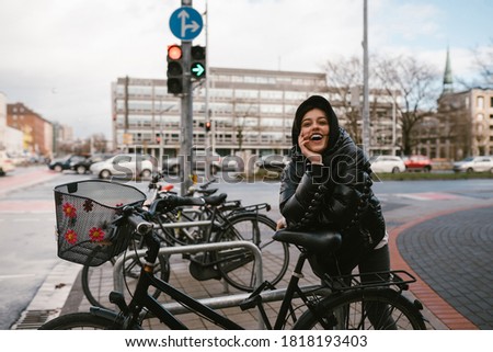 Young woman posing in a parking lot with bicycles