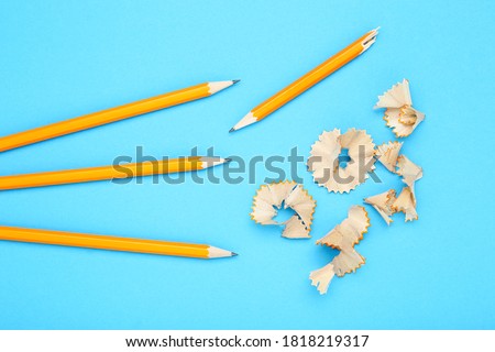 Yellow pencils with shavings on blue background