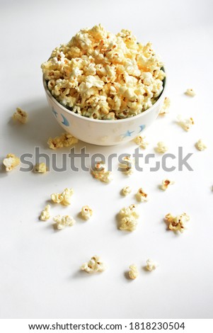 Popcorn bowl isolated in white background, sweet butter or caramel popcorn, salted