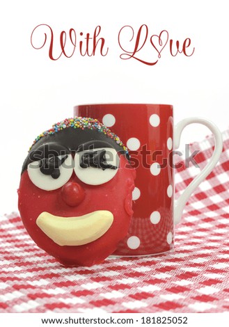 Fun cute children's kids handmade cookie with candy face and red polka dot cup of tea or coffee for Mothers Day, birthday or Fathers day with sample text or copy space.