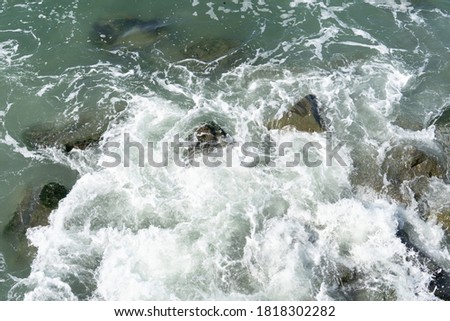Waves breaking over rocks in sea