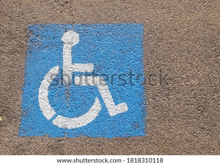 Road signs on asphalt indicating a place for the disabled