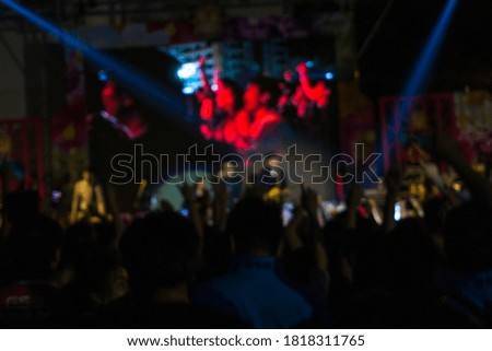 Crowd at concert and blurred colorful stage lights festival Event night time