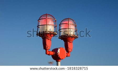 Two red lanterns against a blue sky. Airport navigation lights, horizontal photography.