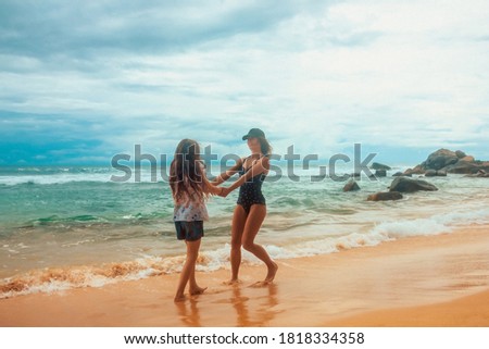 family relationship, mother with daughter are walking on the beach and smiling together. vacation concept, free space	
