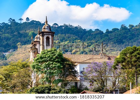 One of the many historic churches in baroque and colonial style from the 18th century amid the hills and vegetation of the city Ouro Preto in Minas Gerais, Brazil