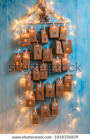 Unique Christmas Advent Calendar as a countdown to holidays on blue wooden background