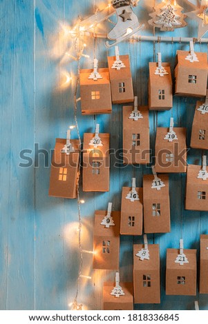 Creative Christmas Advent Calendar as small house with a number on blue wooden background