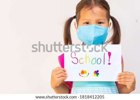Young student going to school, wearing a mask during covid epidemic. School health and safety.
