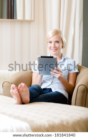 Woman sitting on the sofa with silver pad. Concept of education and online communication