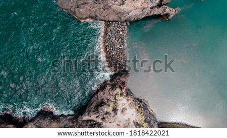 Atlantic ocean bay with cliffs rocks and turquoise waves. Madeira island, Portugal. Aerial drone photography. Panoramic landscape. Natural background. Calm and raging sea. 