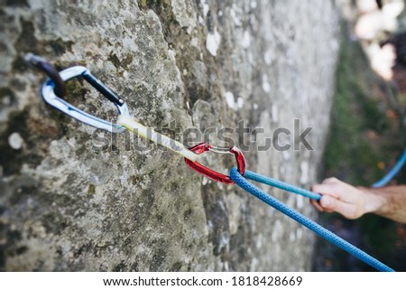 Quickdraw with rope on the rock. Climbing and mountaineering equipmenton the route Royalty-Free Stock Photo #1818428669