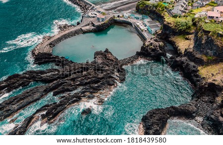 Natural swimming pools among cliffs, Atlantic ocean coastline. Turquoise waves Madeira island, Portugal. Aerial photography from drone. Beautiful panoramic landscape.
