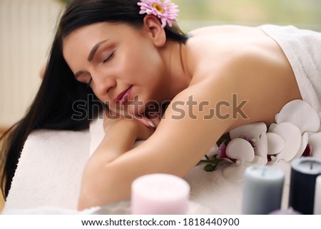 Relaxed woman lying in spa salon with closed eyes, waiting for massage