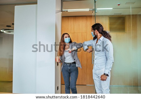 Informal greeting elbow bump by business people in the medical masks in the office during outbreak of the global pandemic COVID-19. Avoiding handshakes in a new normal. Royalty-Free Stock Photo #1818442640