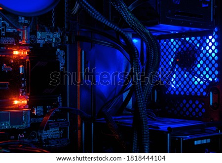 Computer illuminated by internal LED RGB lights, hardware inside open high performance desktop PC. The open tower of gaming computer for wallpaper. Concept of computer repair and modern technology.