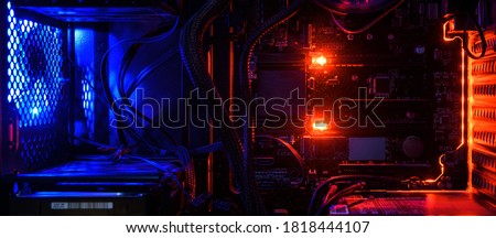 Computer with circuit board and internal LED RGB lights, hardware inside high performance desktop PC for gamer. The open device for wallpaper. Concept of overlocking, repair, server, test, technology