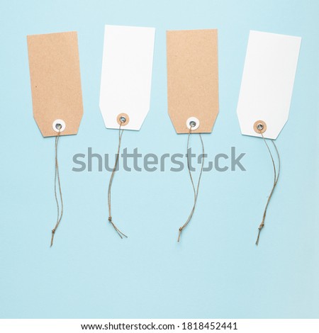 Four blank paper price tag with a knotted string on a blue background