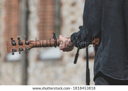 Musician playing guitar and singing outdoors Royalty-Free Stock Photo #1818453818