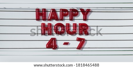 Happy Hour spelled out in red letters on a vintage sign of a bar                              